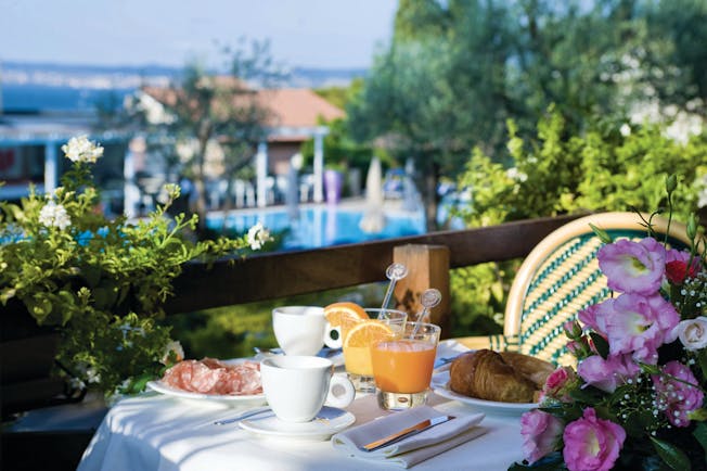 Breakfast layout including cups of tea, orange juice, pastries and a selection of meat