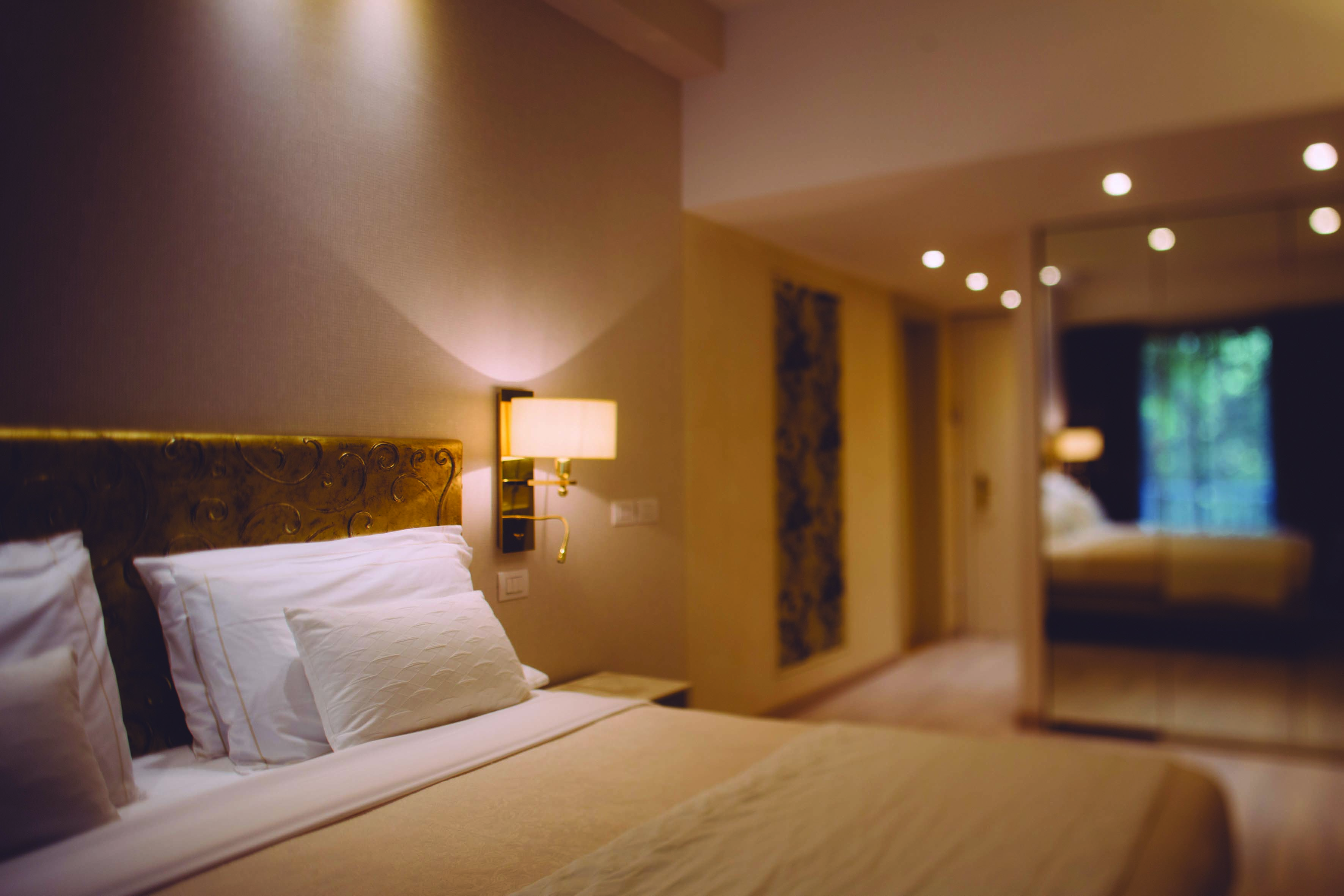 A classic room at the Hotel Olivi with a beige colour scheme, double bed and wardrobe mirror 