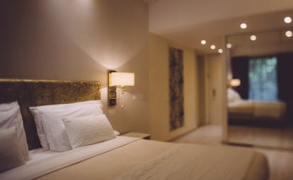 A classic room at the Hotel Olivi with a beige colour scheme, double bed and wardrobe mirror 