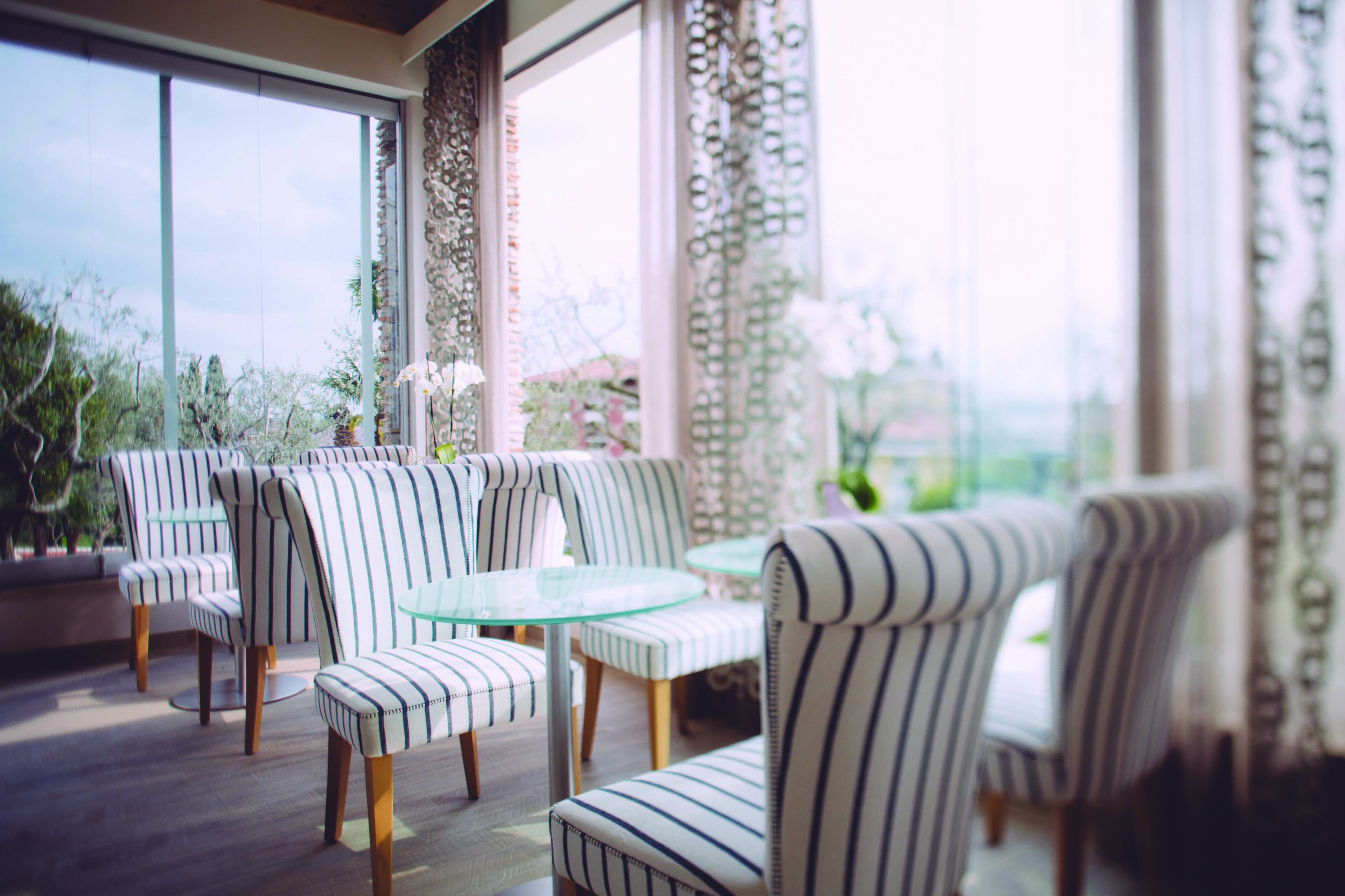 Hotel Olivi dining area with round glass tables and striped seats
