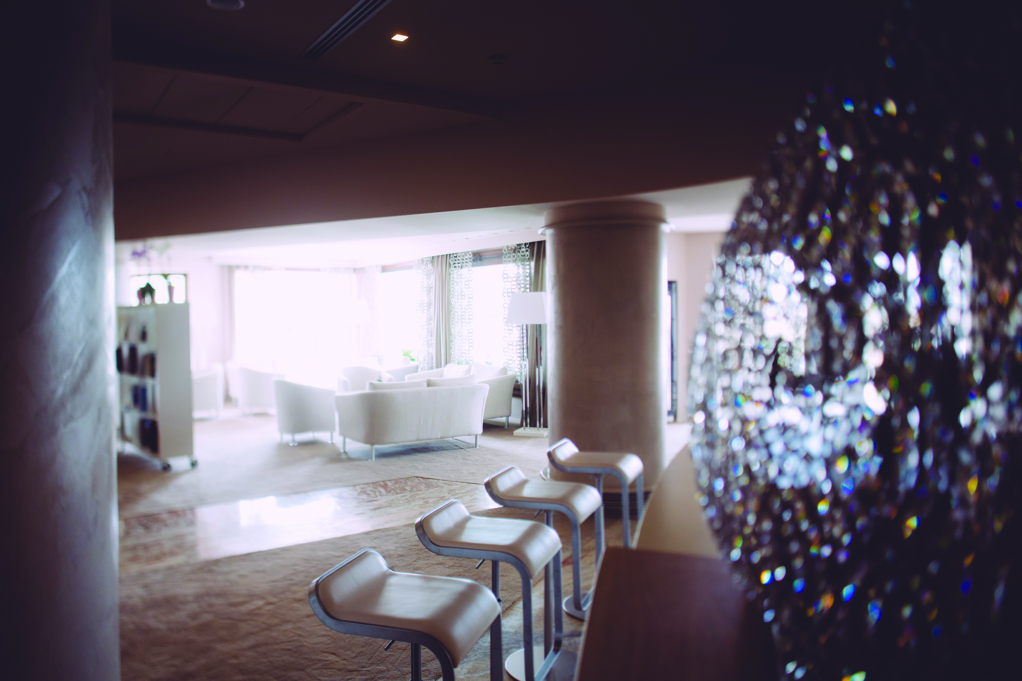White themed hotel lobby with white seating areas around the room 