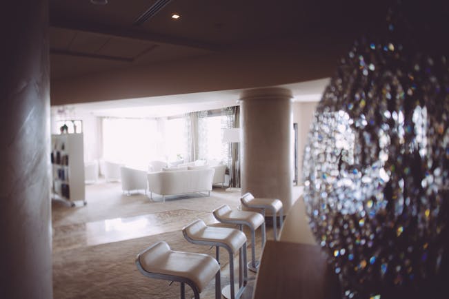 White themed hotel lobby with white seating areas around the room 