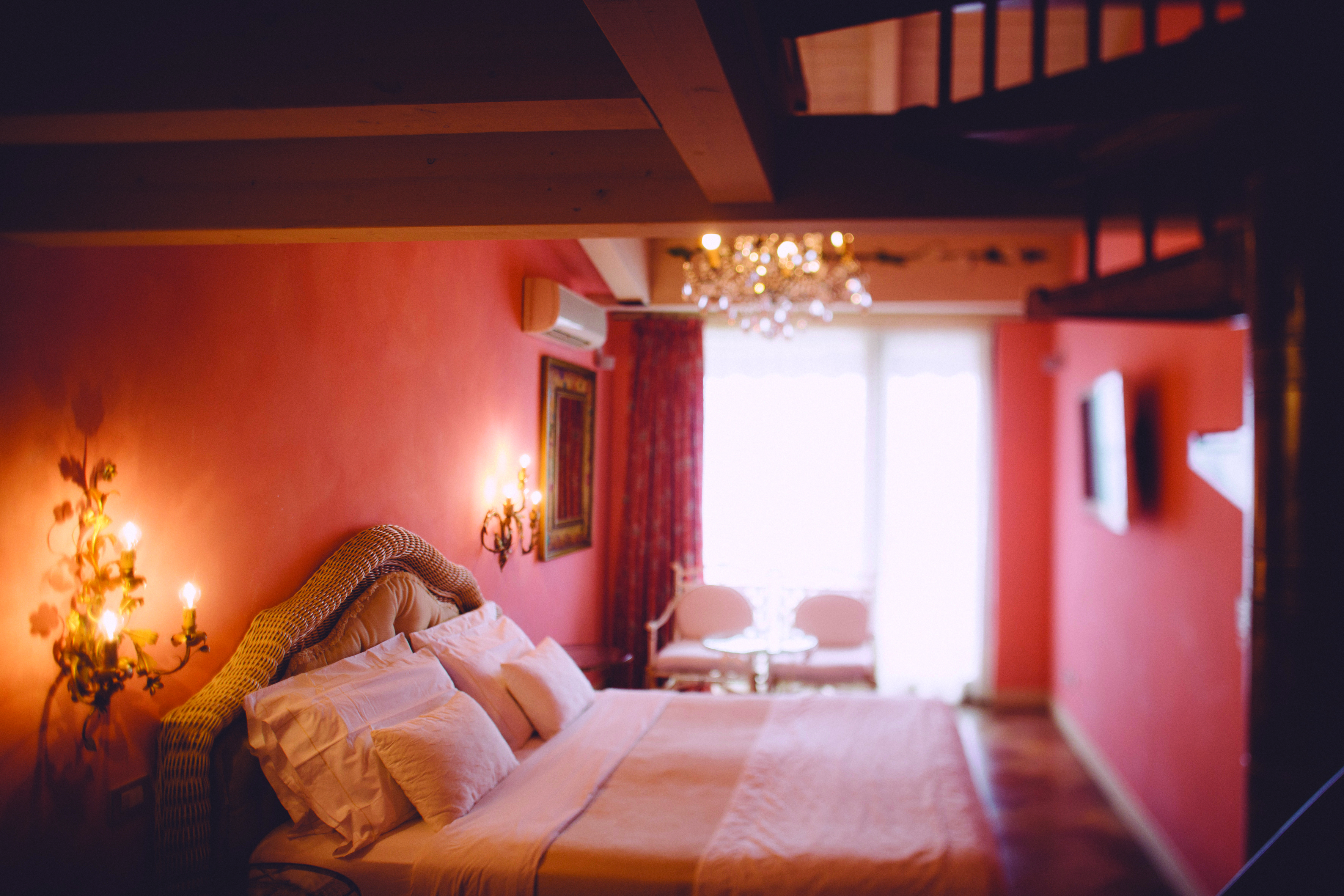 Red themed bedroom with large double bed, red curtains and chandeliers