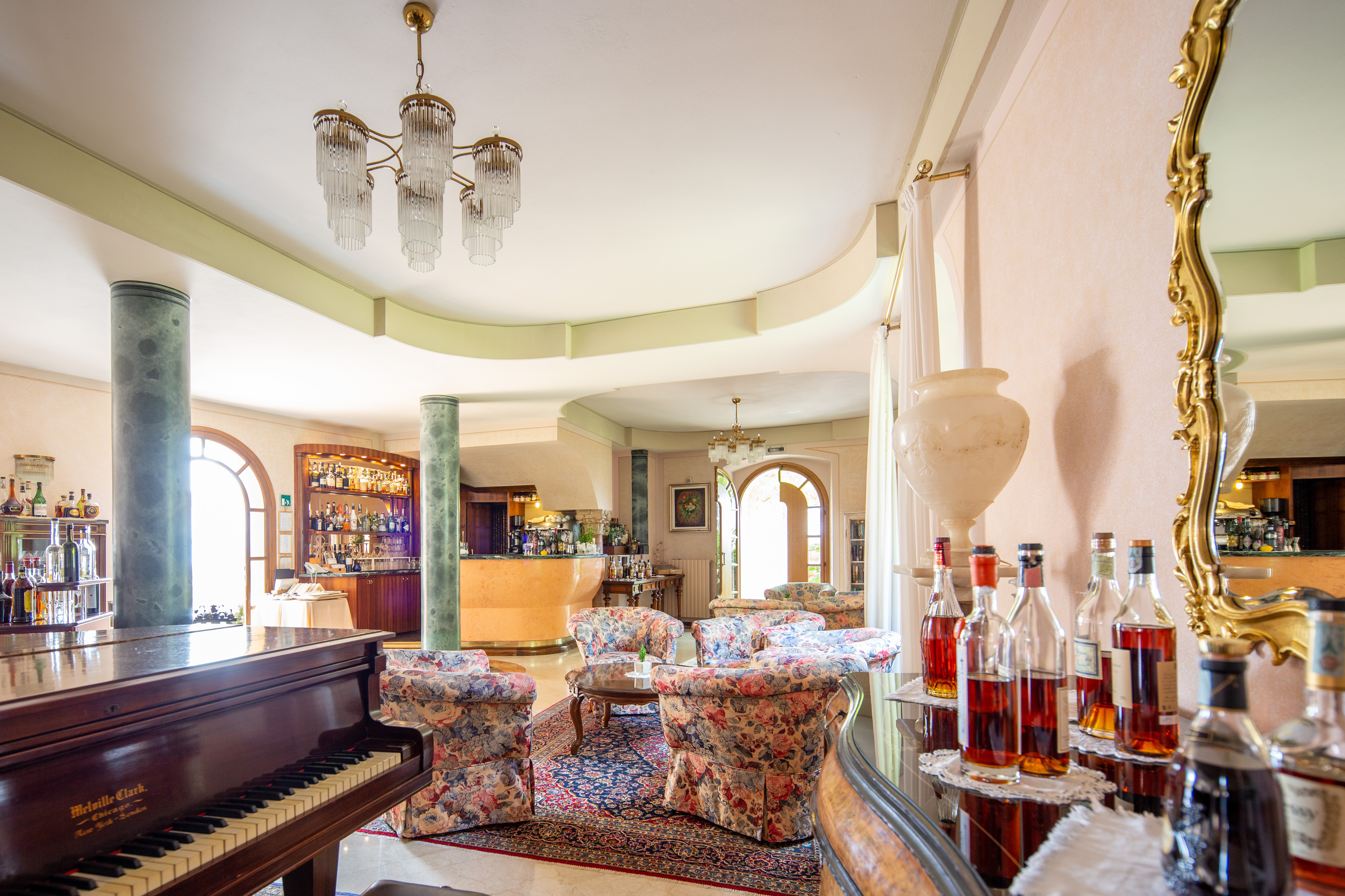Bar with high ceiling, alcoholic drinks behind cabinet and seating areas