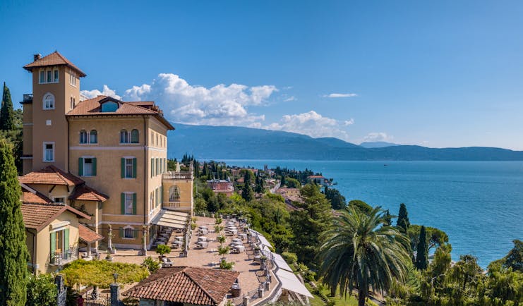 Exterior panorama with hotel building and terrace with view of the lake 