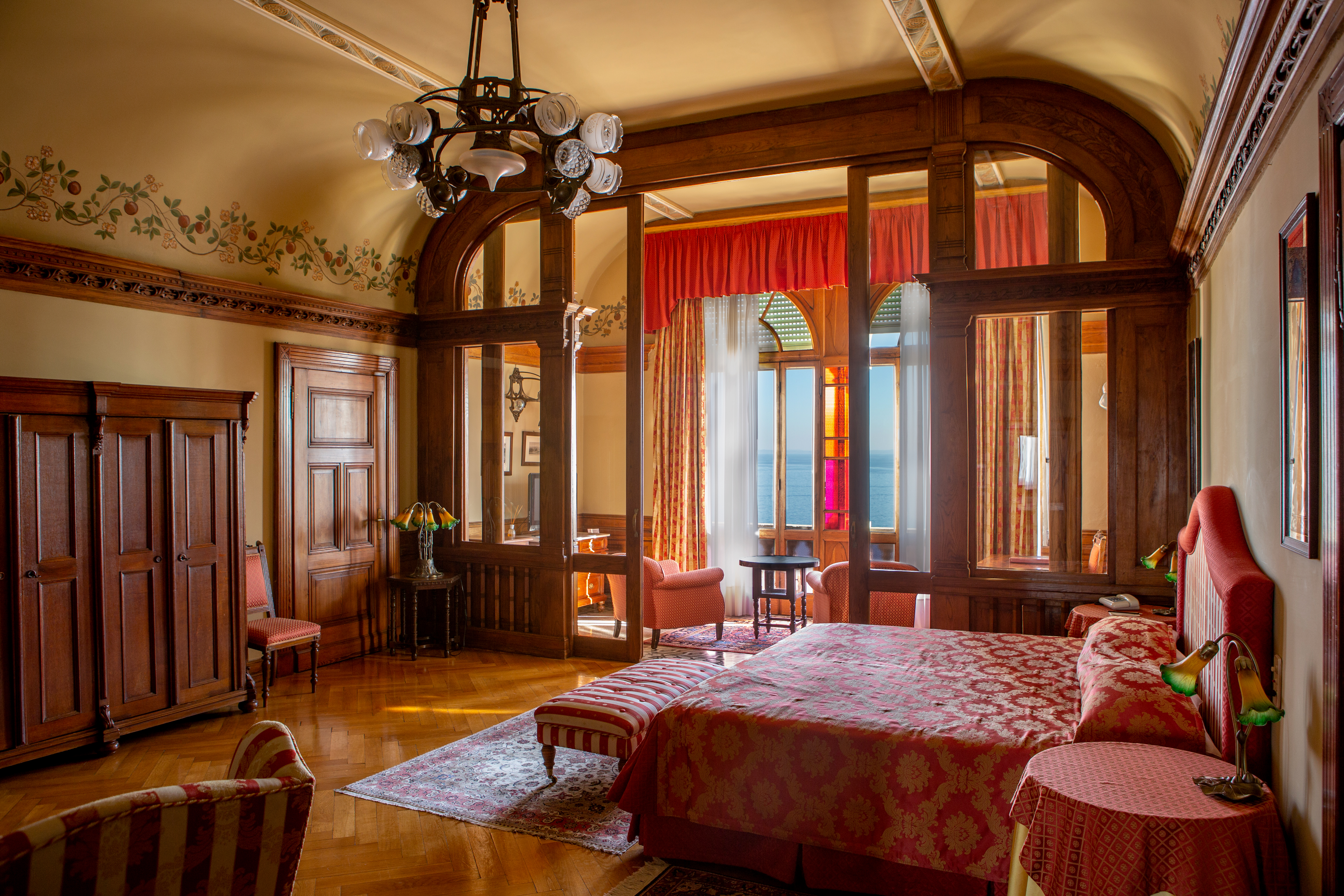 Suite with wood pannelled deorations and red colour scheme with large double bed