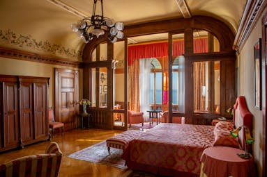 Suite with wood pannelled deorations and red colour scheme with large double bed