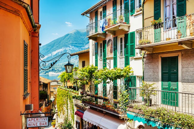 Houses with balconies and green shutters and vines overlooking Lake Como in Bellagio