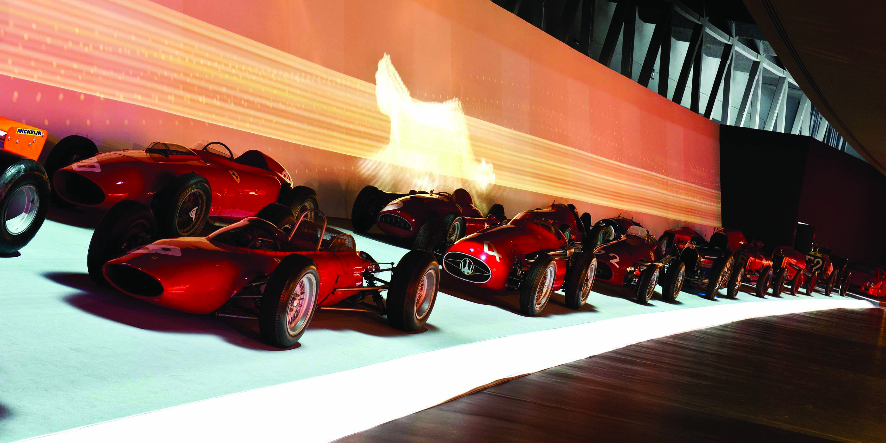 Row of red racing cars in museum