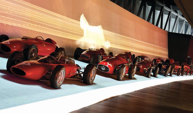 Row of red racing cars in museum