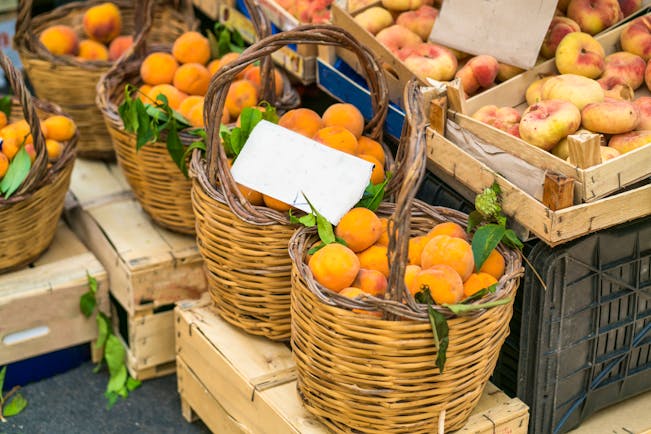 Baskets of fresh peaches in market in Catania in Sicily