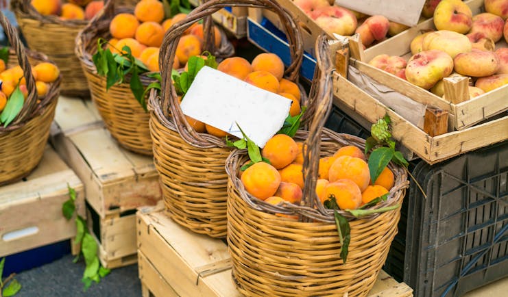 Baskets of fresh peaches in market in Catania in Sicily