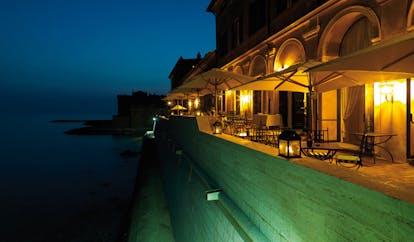 La Posta Vecchia Latium terrace at night outdoor dining area overlooking sea