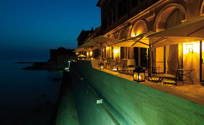 La Posta Vecchia Latium terrace at night outdoor dining area overlooking sea