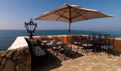 La Posta Vecchia Latium terrace tables chairs umbrella overlooking sea