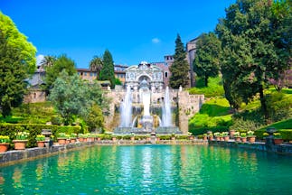 Turquoise pond with jets of water from fountains with terraced stone landscape and trees at Villa d'Este Tivoli near Rome