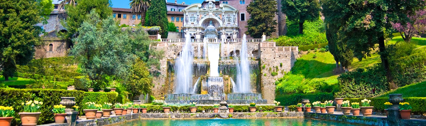 Turquoise pond with jets of water from fountains with terraced stone landscape and trees at Villa d'Este Tivoli near Rome