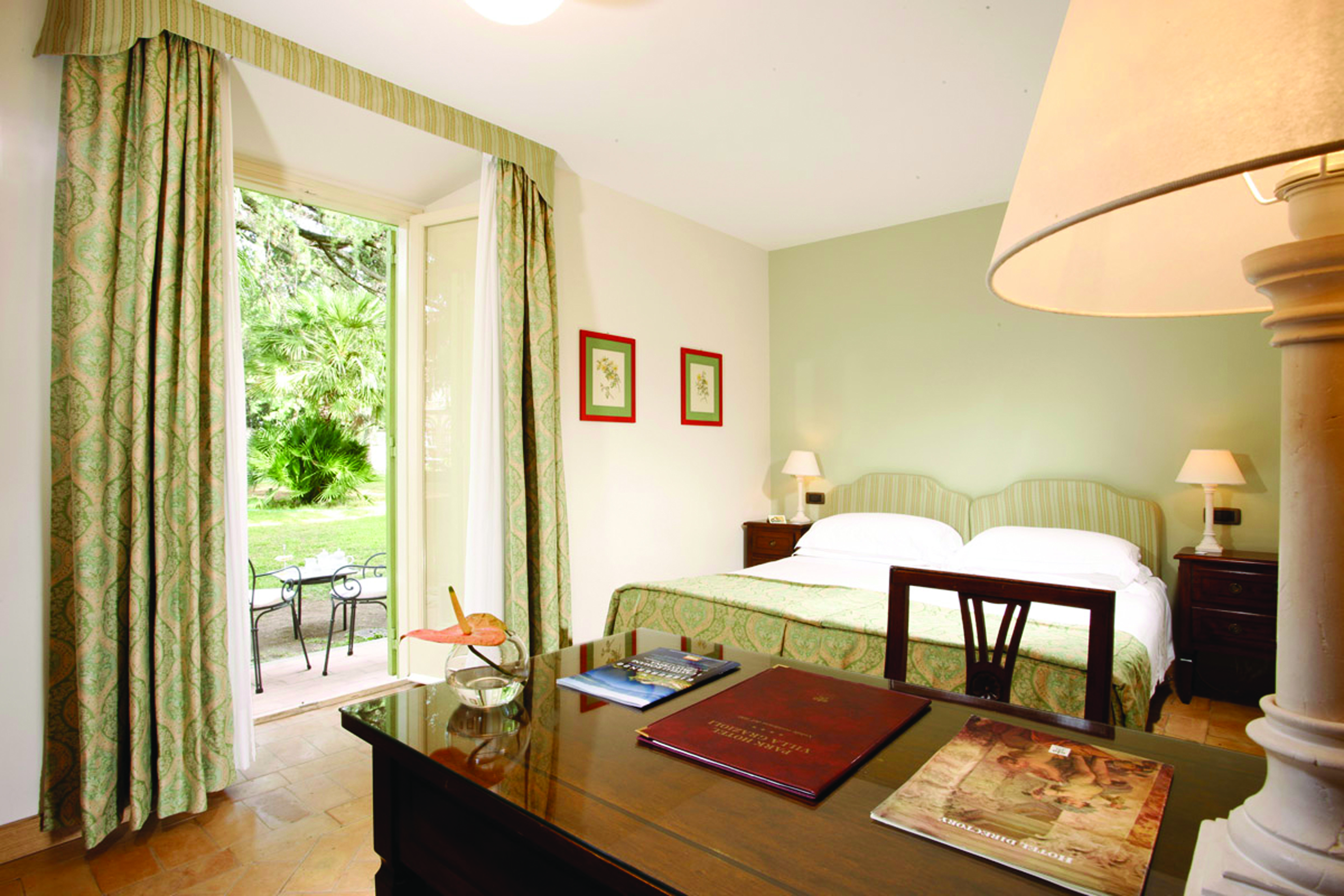 Vila Grazioli Latium charme deluxe room bedroom leading out to garden and outdoor seating area