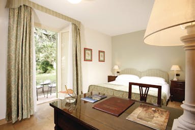 Vila Grazioli Latium charme deluxe room bedroom leading out to garden and outdoor seating area