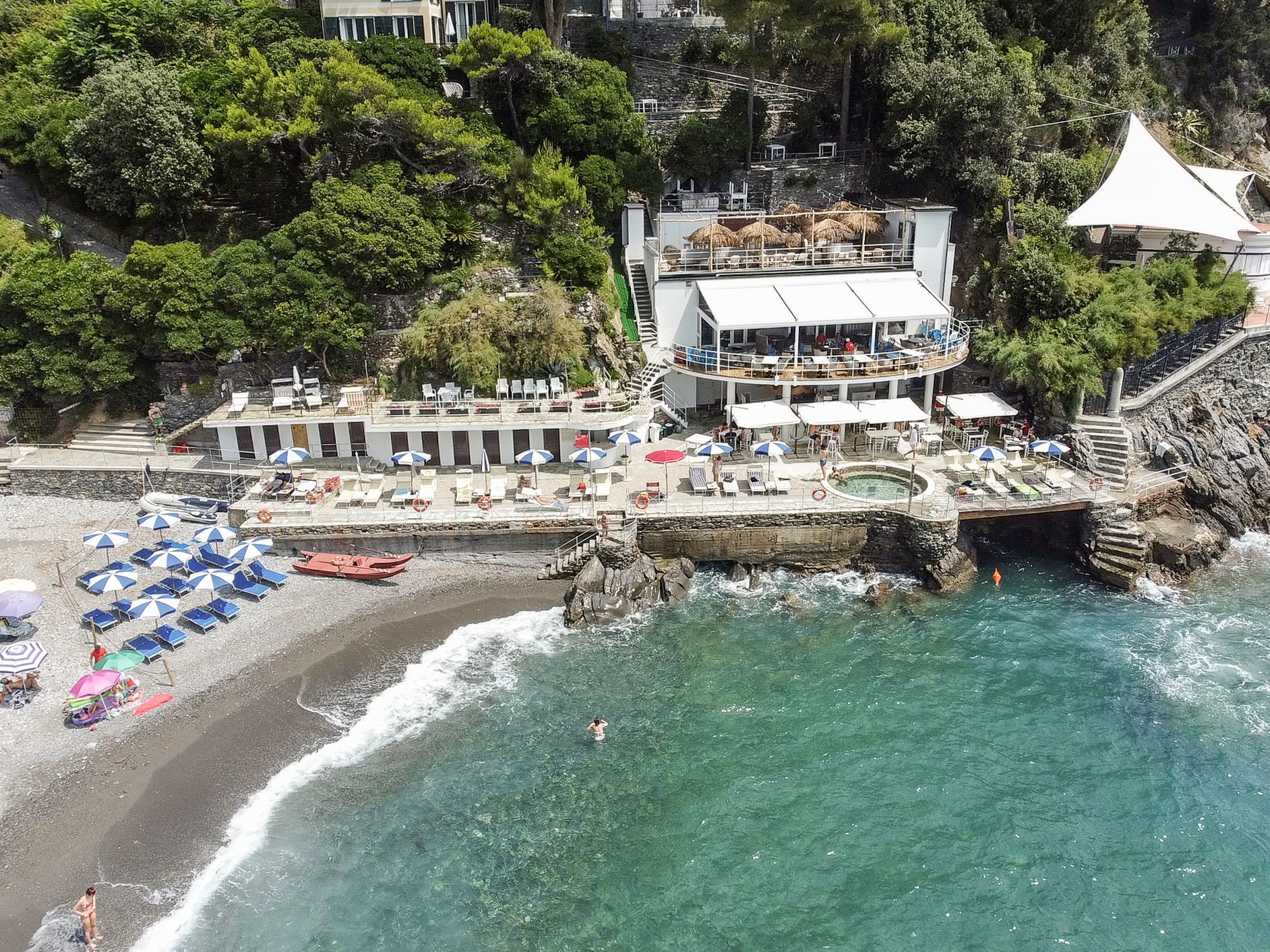 Grand Hotel Bristol Resort & Spa Beach Club seen from above, with beach area, terrace above the waves, and a restaurant building set into the wooded hillside