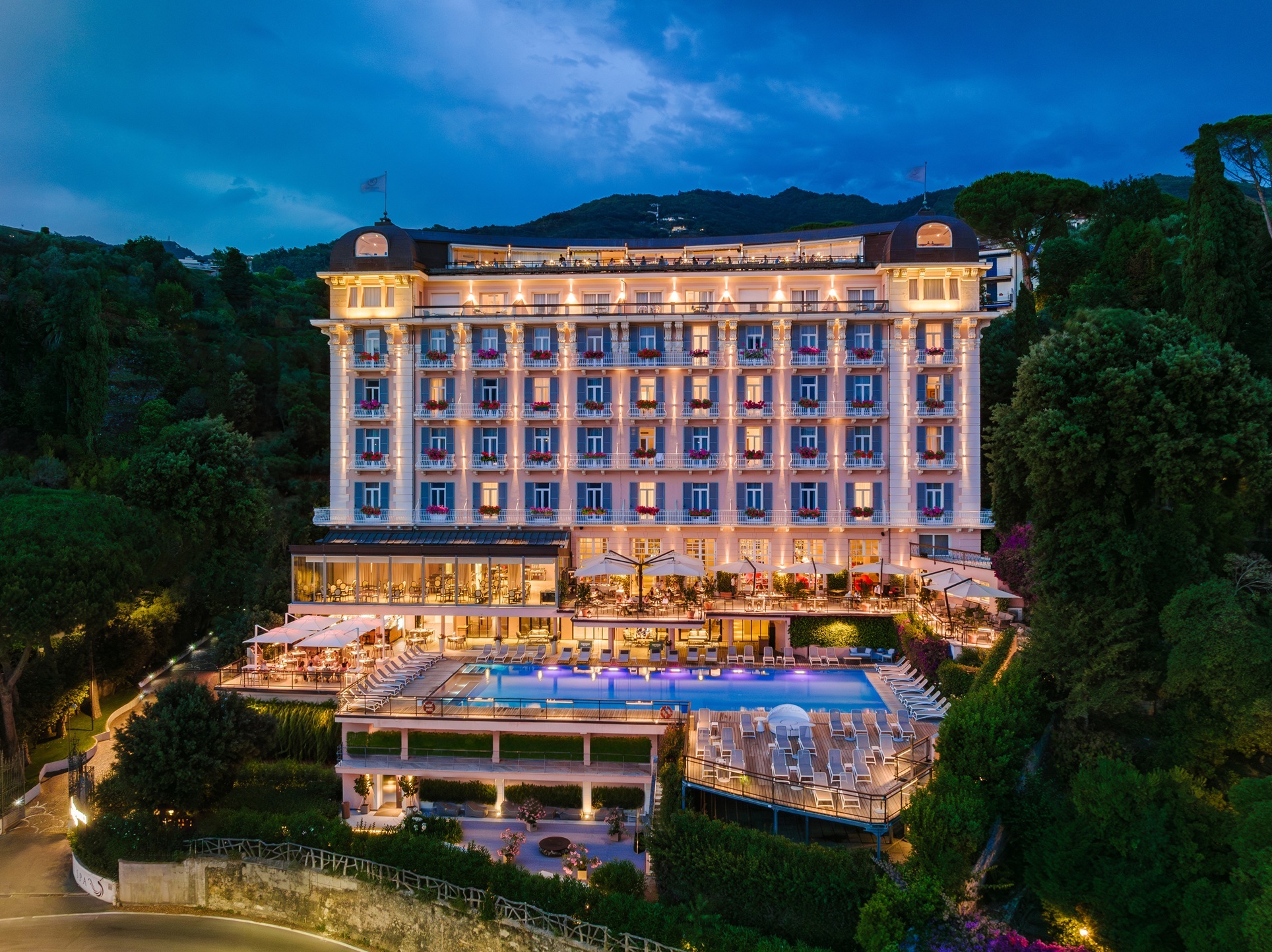 Grand Hotel Bristol Resort & Spa exterior at night, showing a grand facade and pool terrace, framed by abundant trees