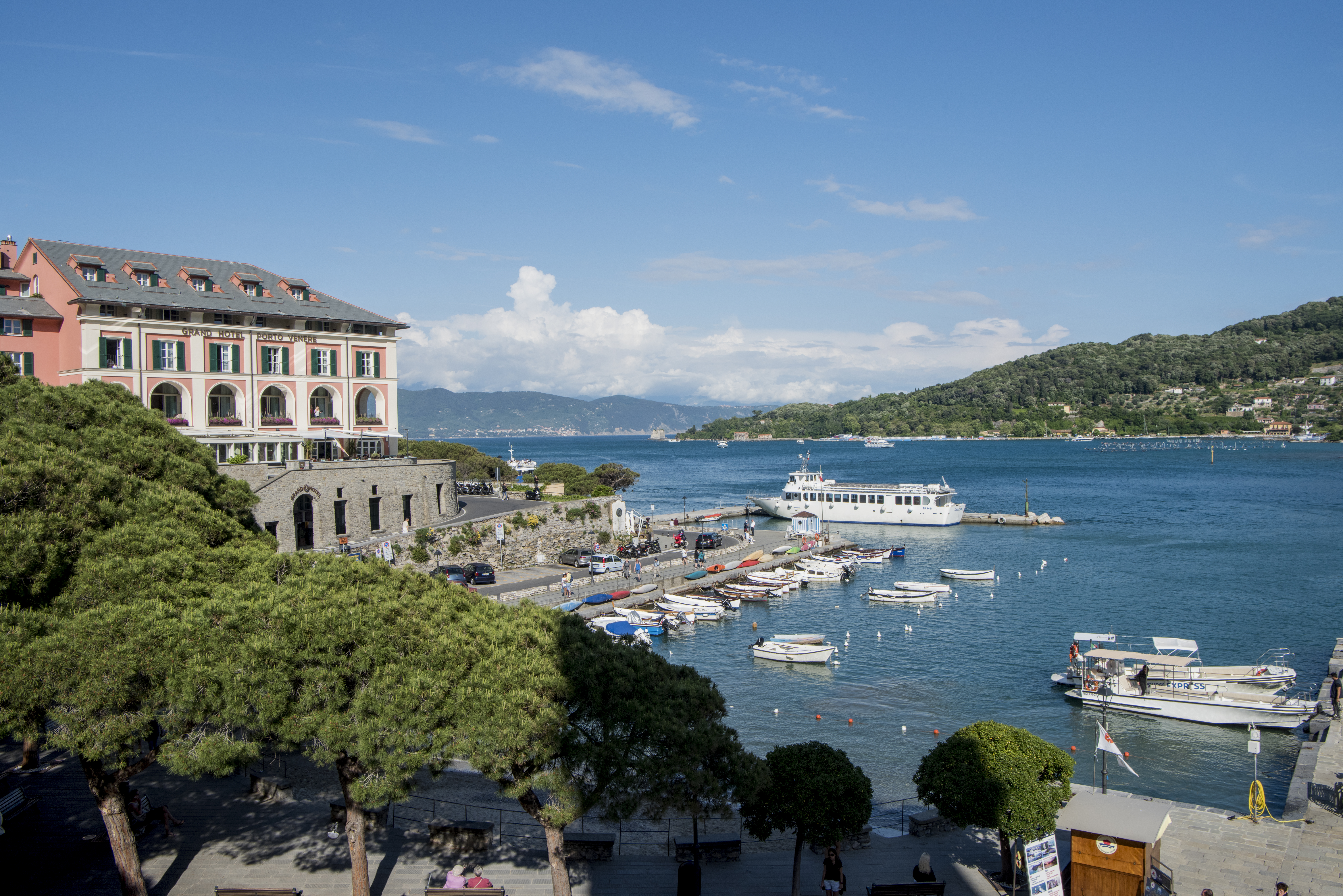 Building of hotel on a slight hill overlooking a port with hills in the distance at the Grand Hotel Portovenere