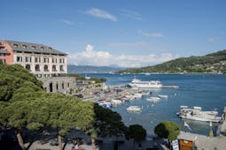 Building of hotel on a slight hill overlooking a port with hills in the distance at the Grand Hotel Portovenere