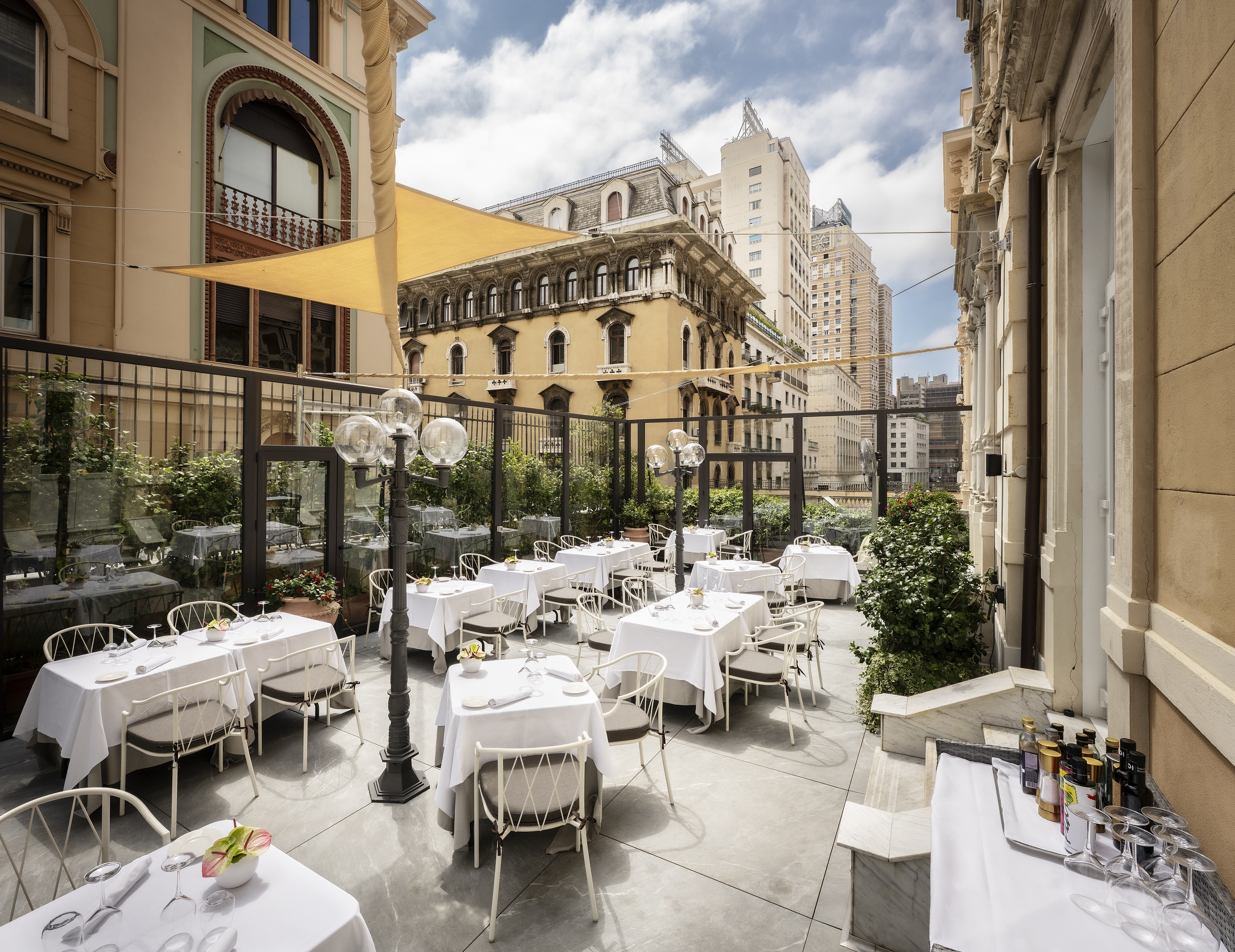 Hotel Bristol Palace courtyard with white-clothed dining tables, with stone townhouses on every side
