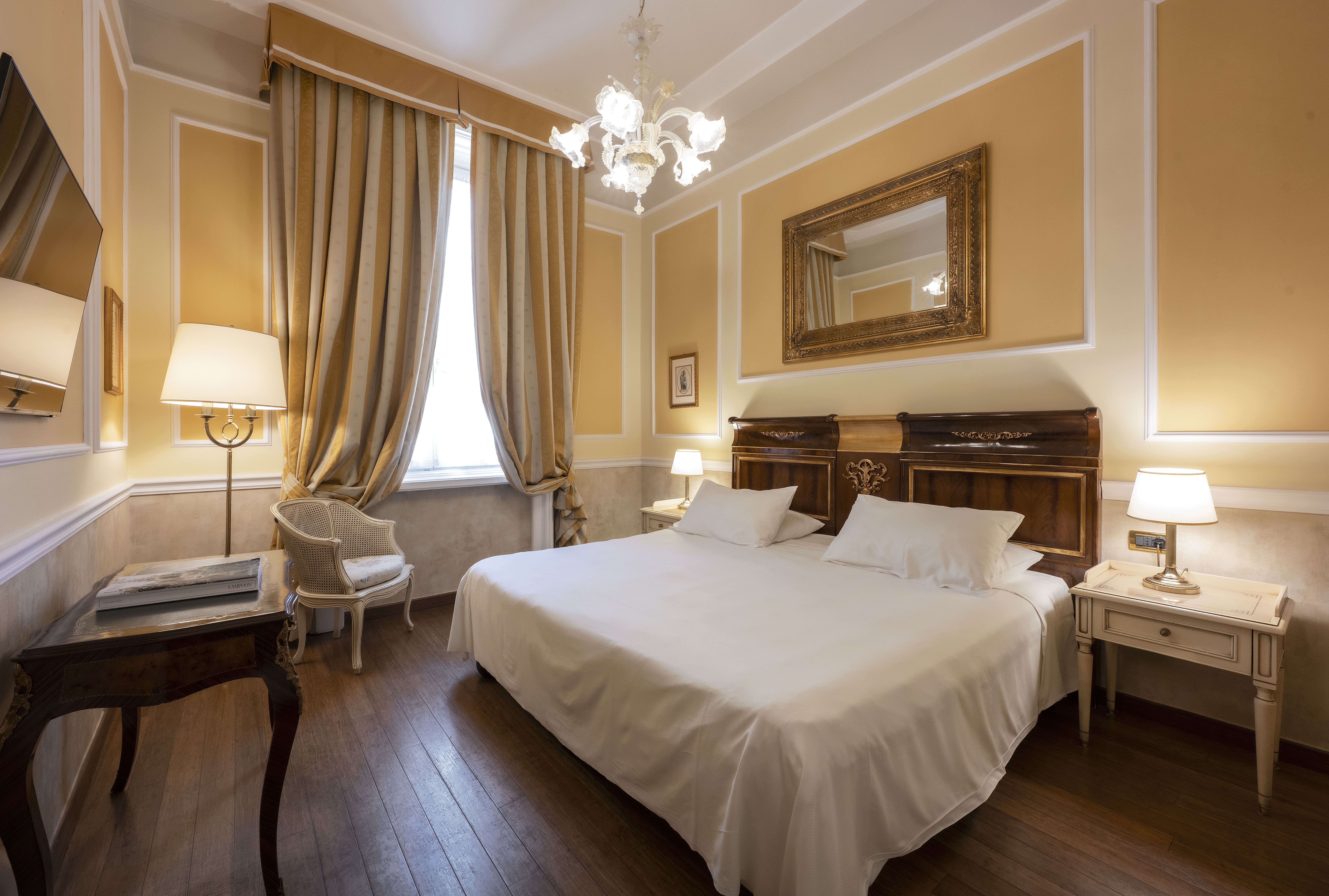 Hotel Bristol Palace room with warm neutral decor, draped curtains, wooden furnshings and gold lamps