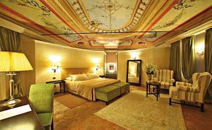 Relais Sant'Uffizio Piemonte suite Sant Uffizio bed chairs modern décor ornately painted ceiling