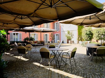 Villa D'Amelia Piemonte cobbled patio with tables and chairs and sunshades
