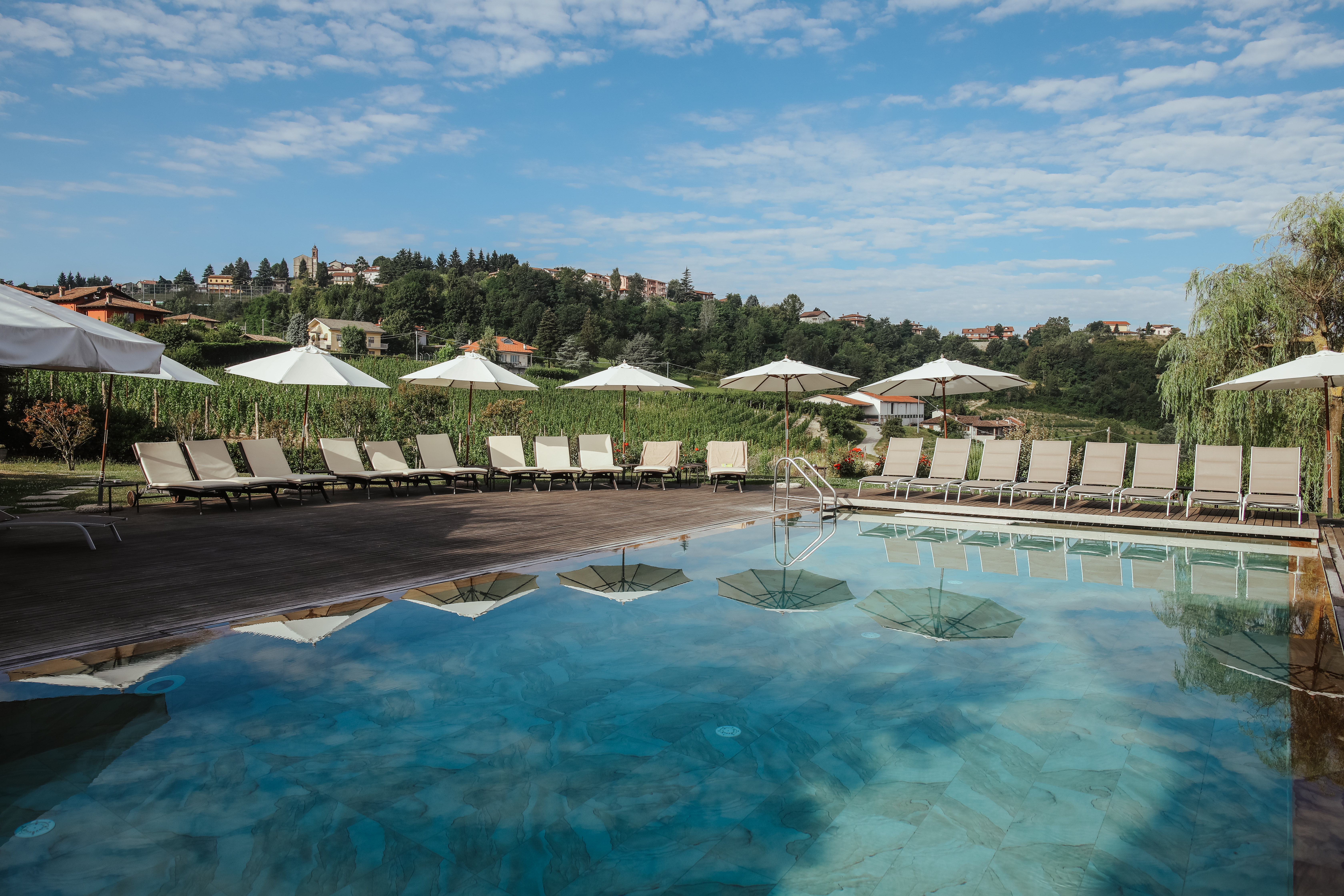 Villa D'Amelia Piemonte swimming pool with white umbrellas reflected in water