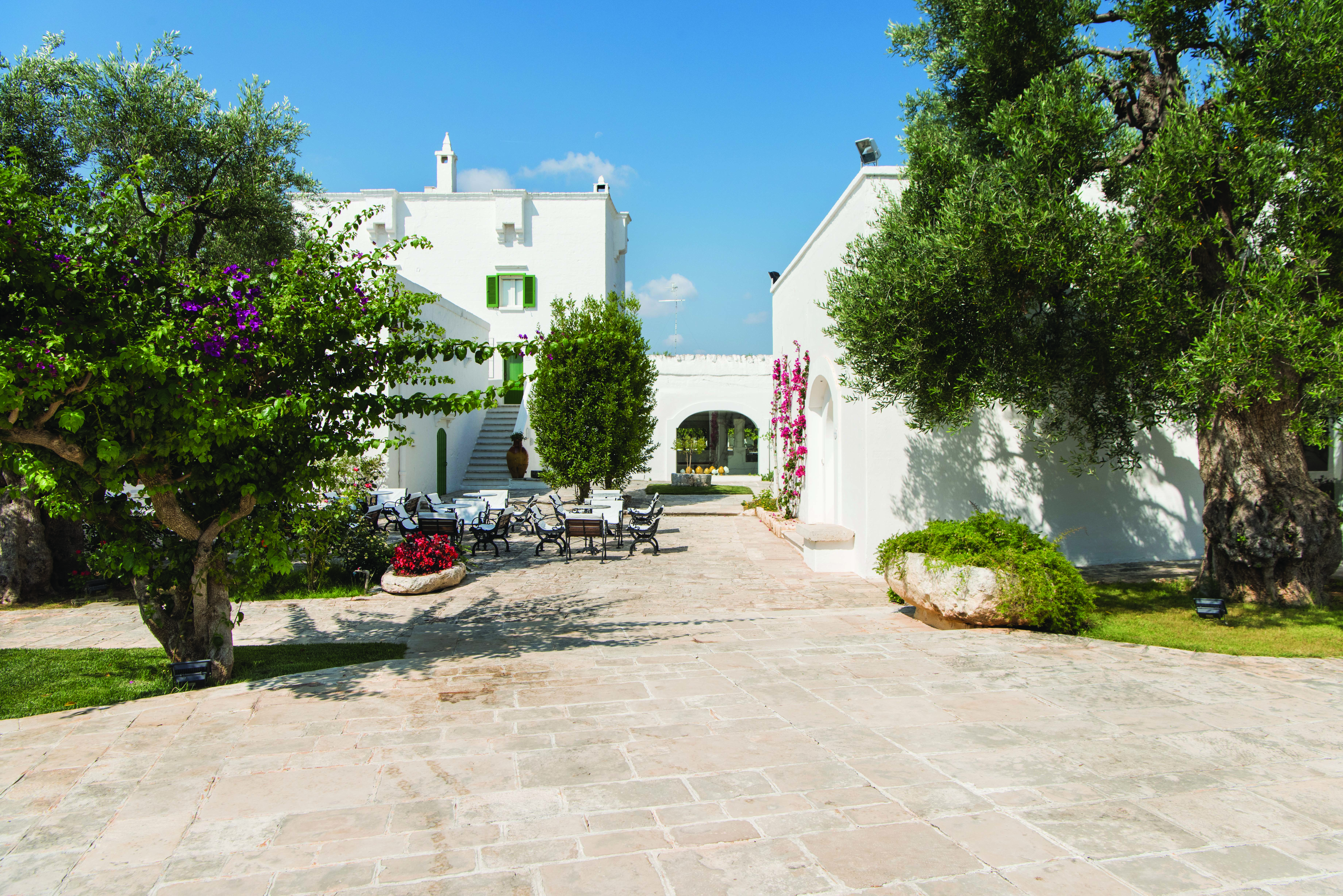 Il Melograno Puglia exterior white building outdoor dining area trees