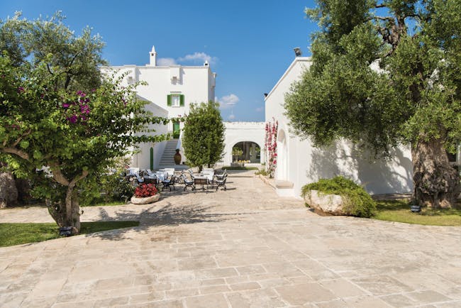 Il Melograno Puglia exterior white building outdoor dining area trees