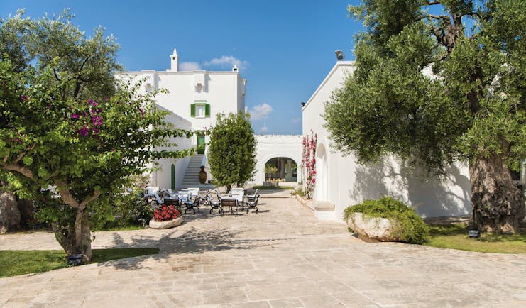 Il Melograno Puglia exterior white building outdoor dining area trees