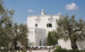 Il Melograno Puglia hotel exterior white building trees outdoor dining area