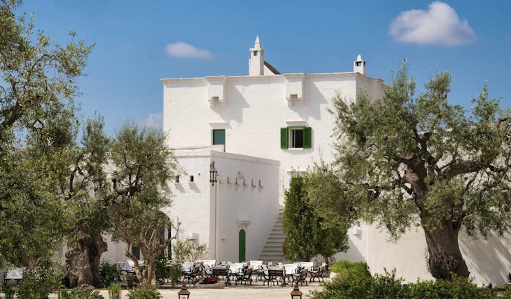 Il Melograno Puglia hotel exterior white building trees outdoor dining area