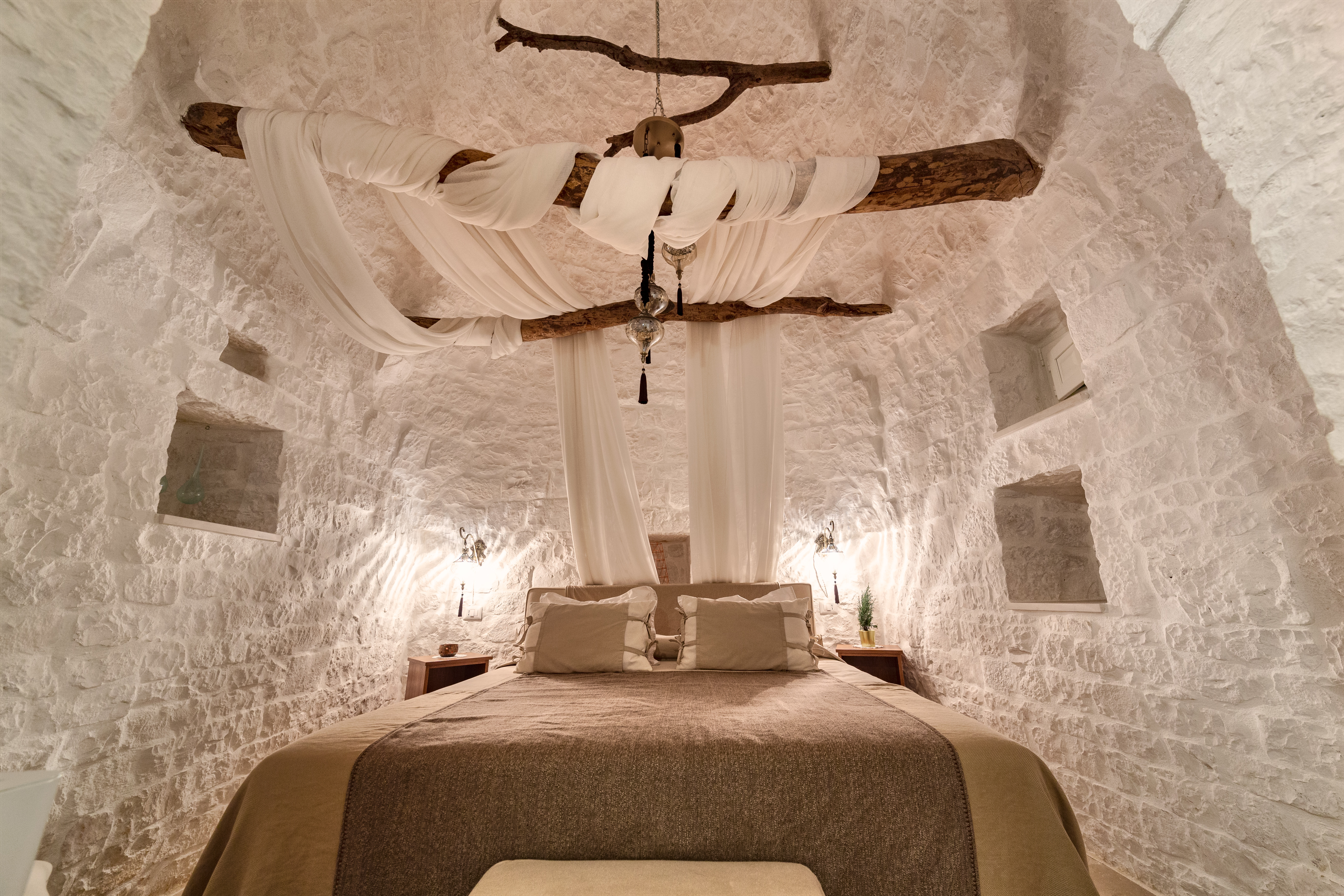 Leonardo Trulli Resort Superior Room with classic trulli coned roof above a bed dressed in neutral fabrics
