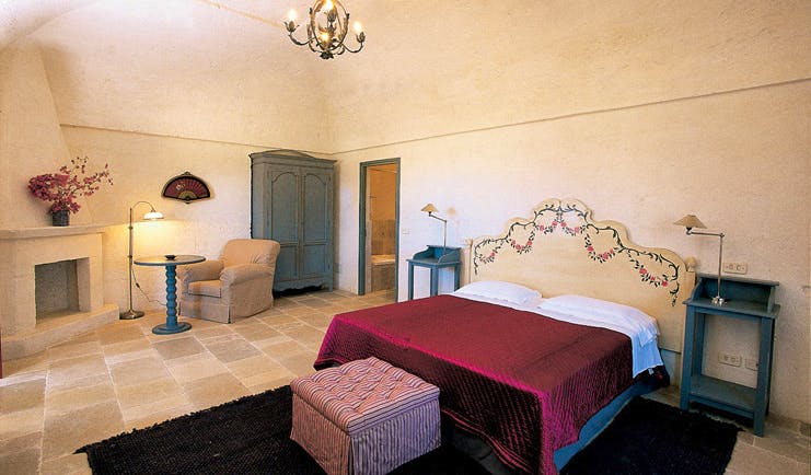 Masseria Torre Coccaro Puglia superior room bed fireplace wardrobe elegant décor
