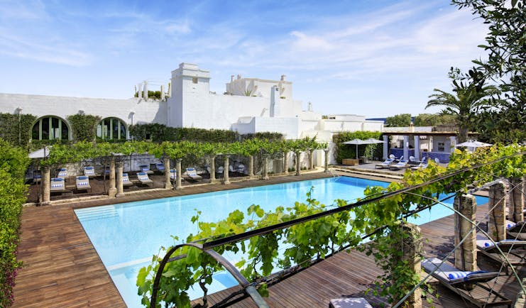 White square building with outdoor pool and sun deck at Torre Maizza