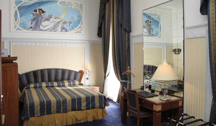 Bedroom at the Patria Palace Lecce with blue and brown striped bedspread