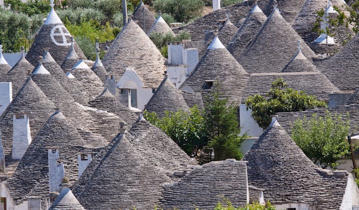 Conical grey slate roofs of the Trulli houses clustered together in Alberobello Puglia