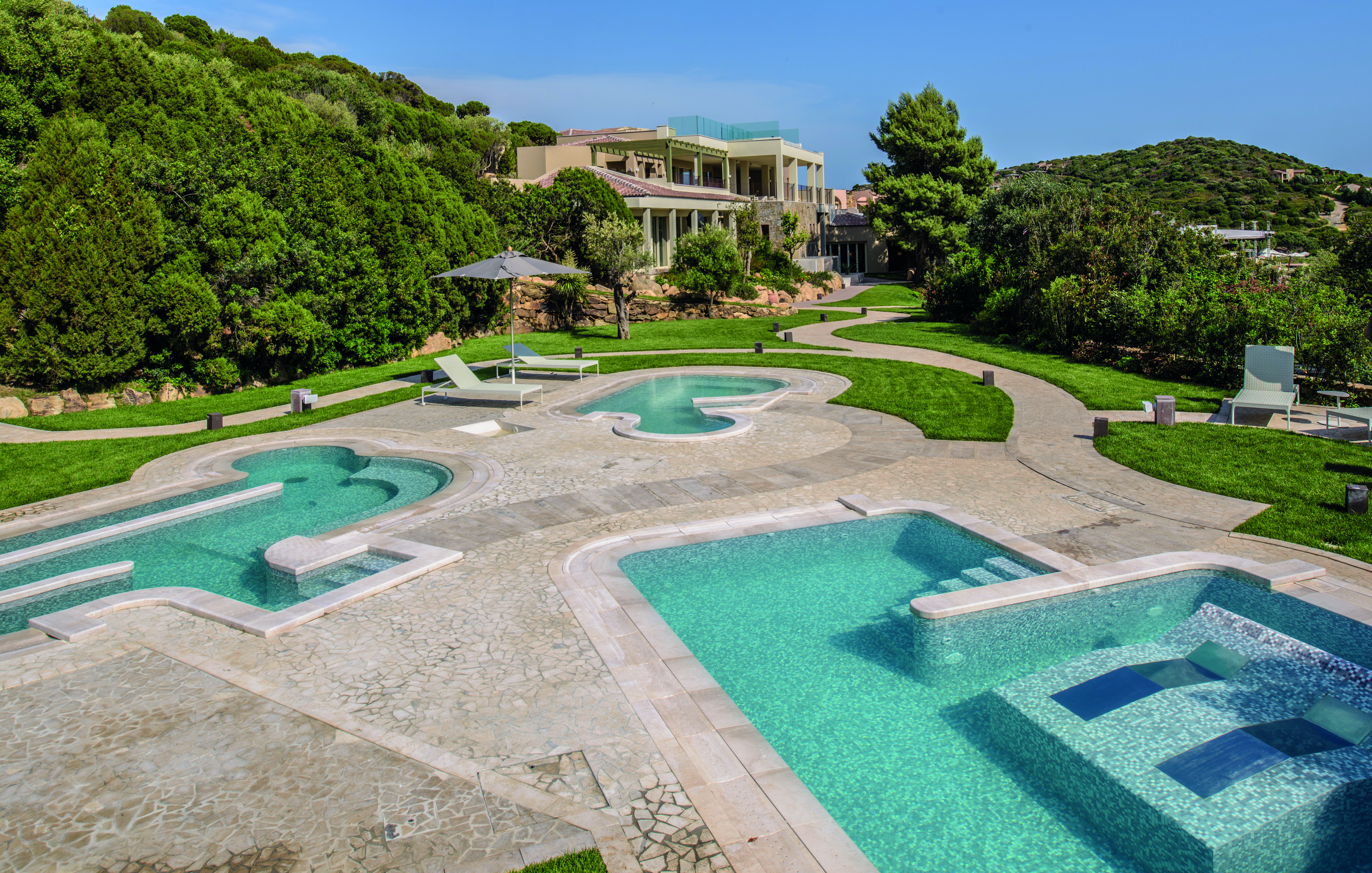 Chia Laguna Natural Spa with mini different shaped plunge pools scattered around a concrete floor