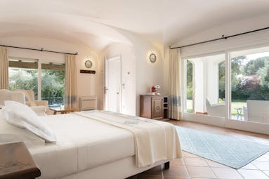 La Rocca Sardinia villa del parco junior suite living area bed patio doors leading to garden
