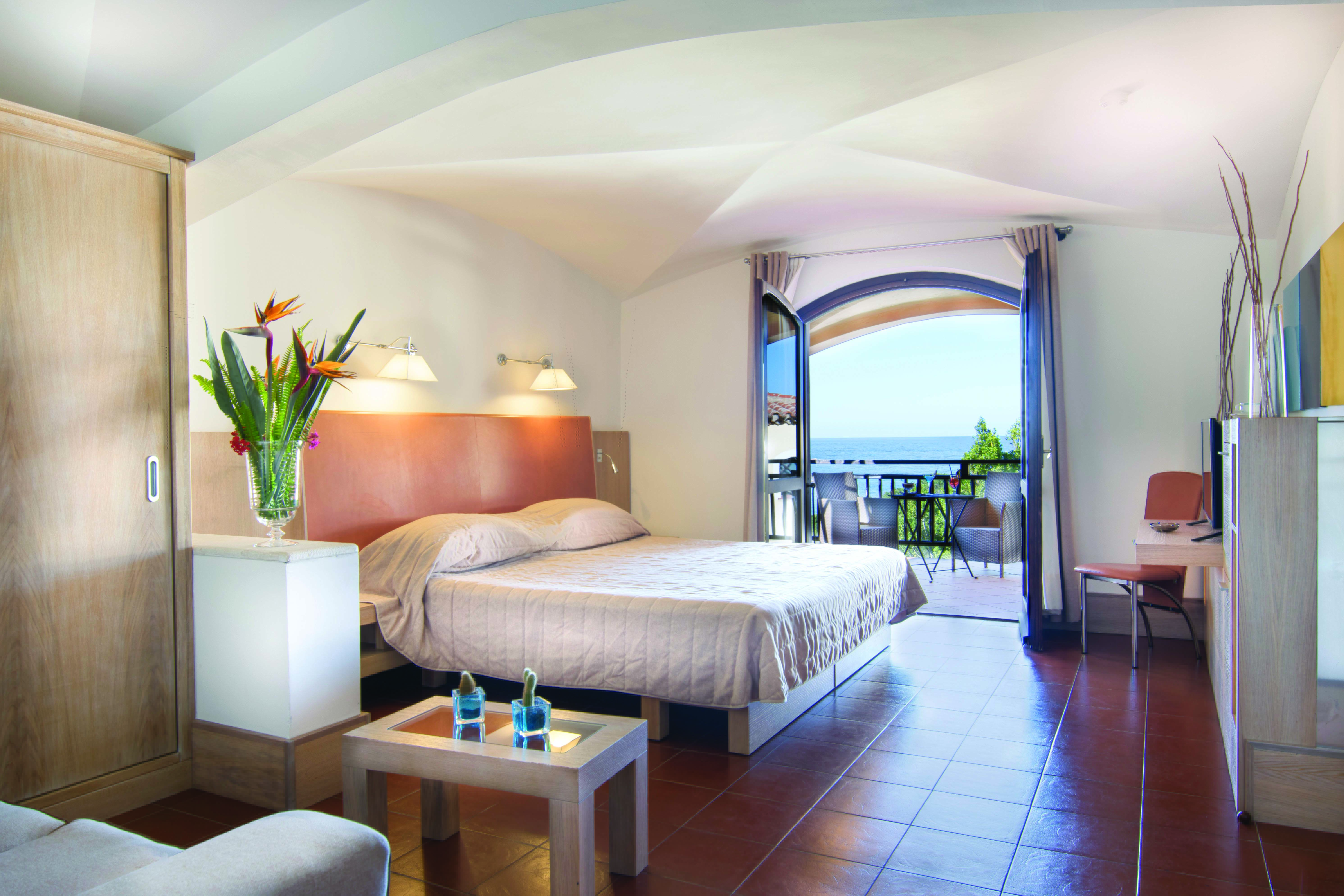 Hotel Le Ginestre Sardinia junior suite, double bed, living area, doors to private balcony with sea view