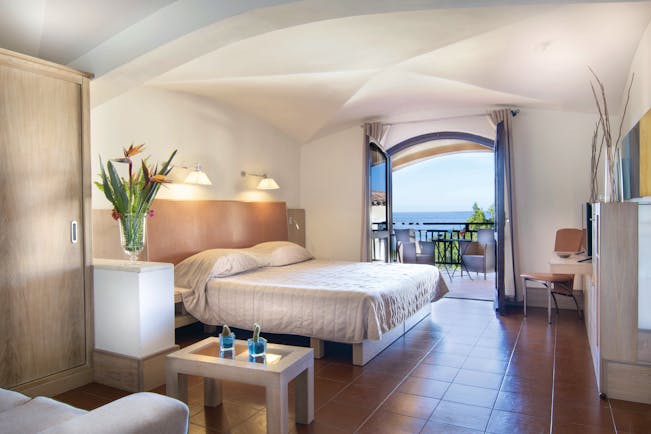 Hotel Le Ginestre Sardinia junior suite, double bed, living area, doors to private balcony with sea view