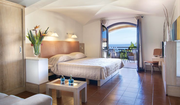 Hotel Le Ginestre Sardinia junior suite, double bed, living area, doors to private balcony with sea view