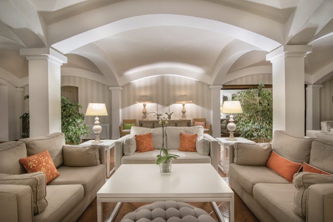 Hotel Le Ginestre Sardinia lobby, communal seating area, large white sofas, bright elegant decor