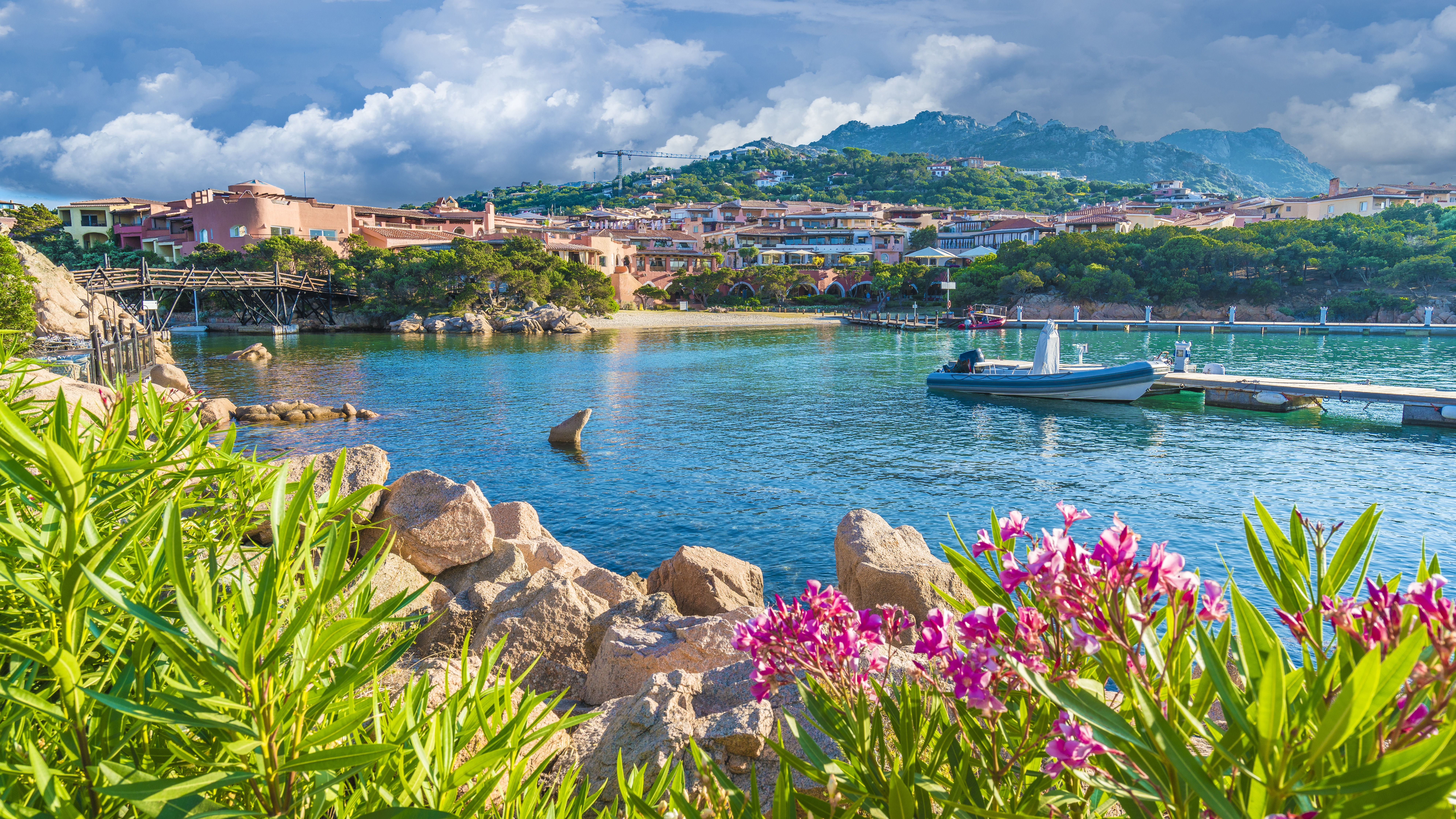 Turquoise calm sea flanked by pink hibiscus flowers in Porto Cervo Sardinia