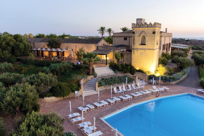 Baglio Oneto pool, pool deck with sun loungers, hotel building in background, traditional architectural features